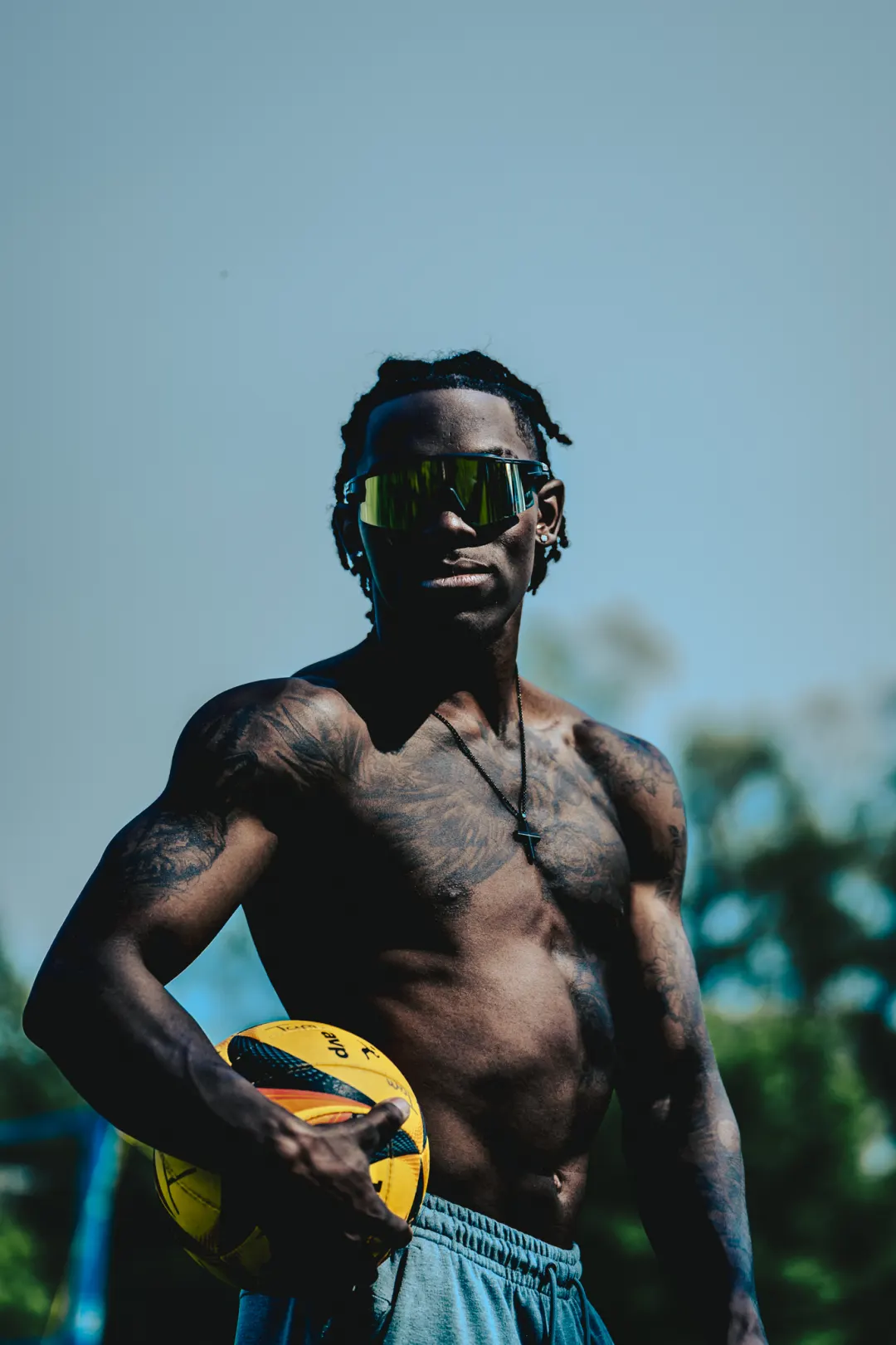 Beach volleyball player holding a yellow and blue ball