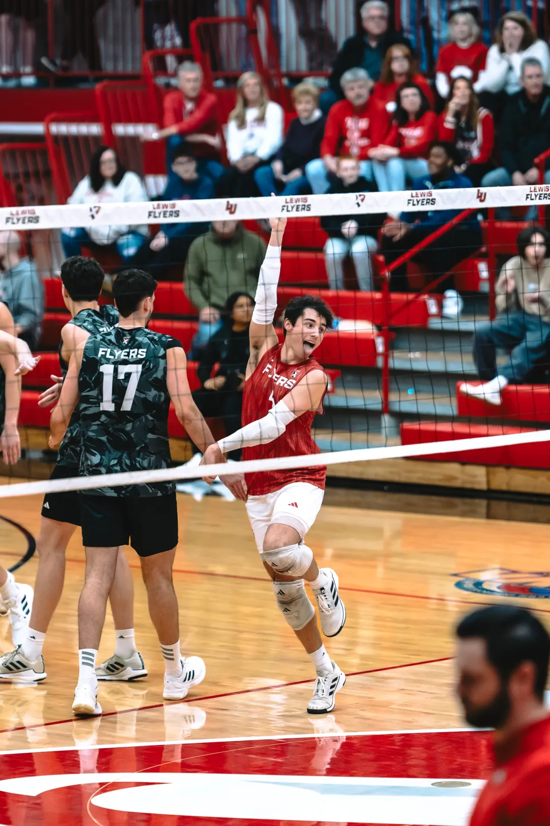 Indoor volleyball player attacking above the net