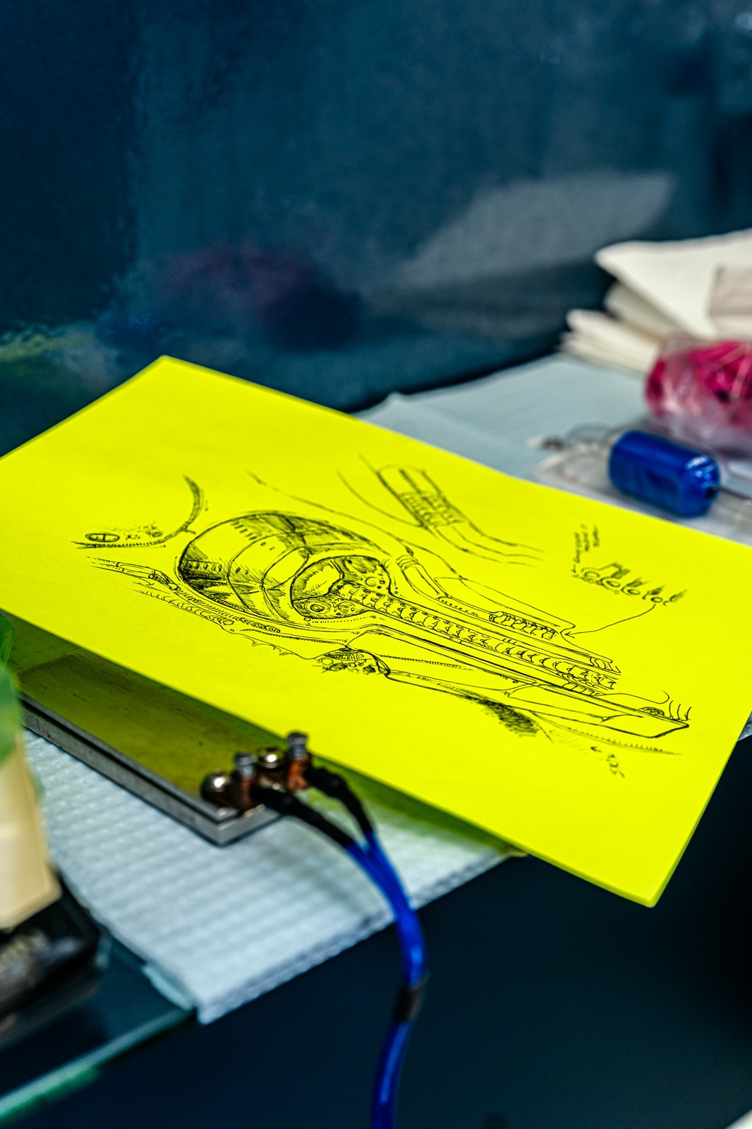 A drawing of a mechanical skull rests on a yellow sheet of paper.