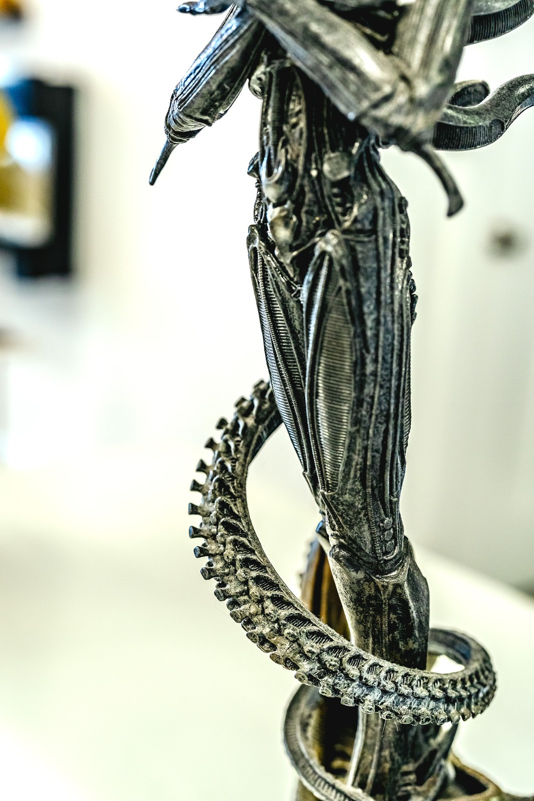 A metallic figure with a coiled tail is shown in detail.