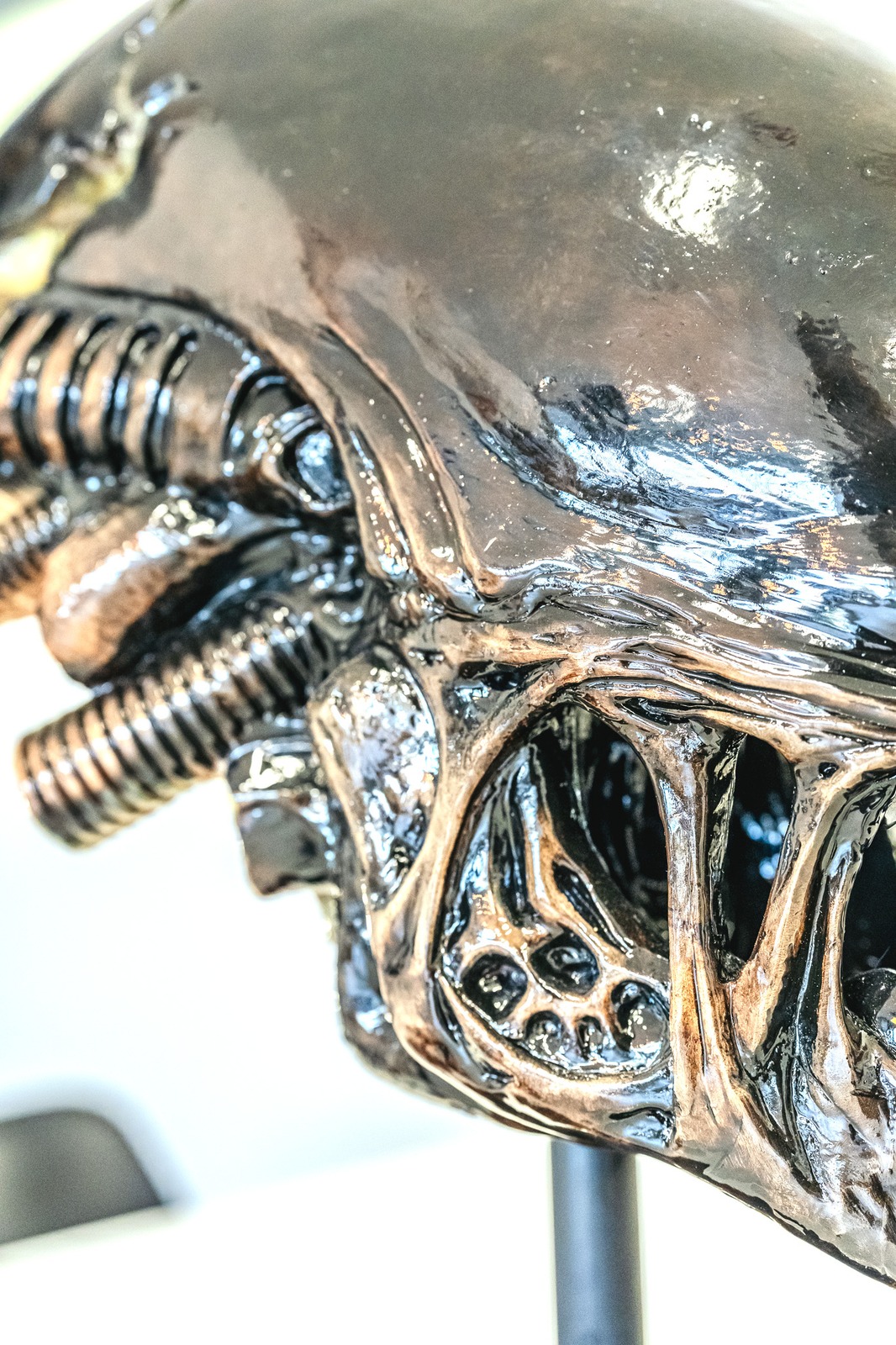Close-up of a detailed alien head sculpture with metallic and glossy textures.