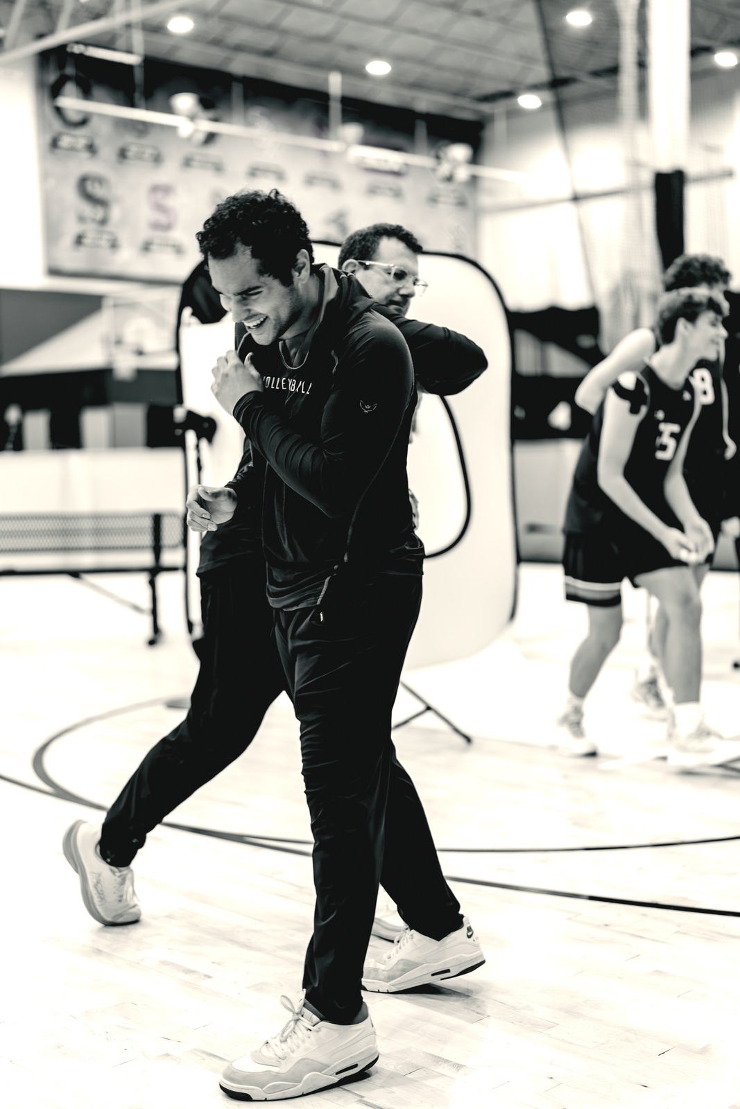 Two people in black hold each other with arms raised beside the photo setup.
